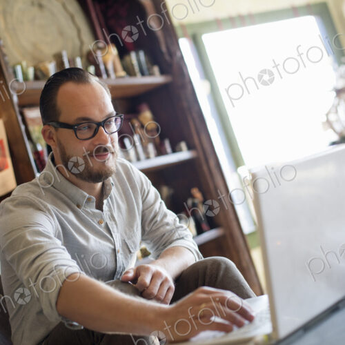 A man sitting at a desk using a laptop computer. Running a small business.