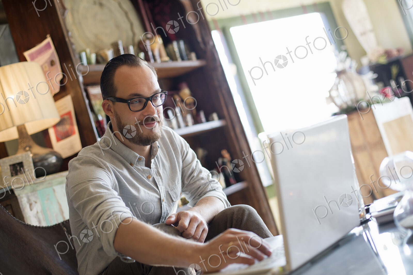A man sitting at a desk using a laptop computer. Running a small business.