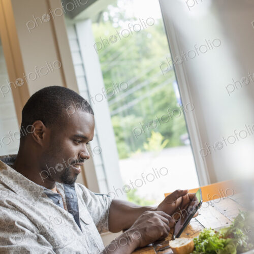 A man sitting in a cafe with a cup of coffee. Using a smart phone. A man sitting in a cafe with a cup of coffee. Using a smart phone.
