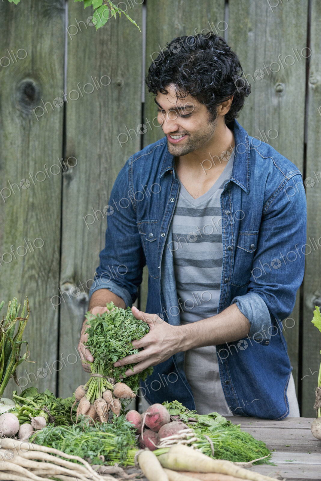 A man sorting freshly picked vegetables on a table.