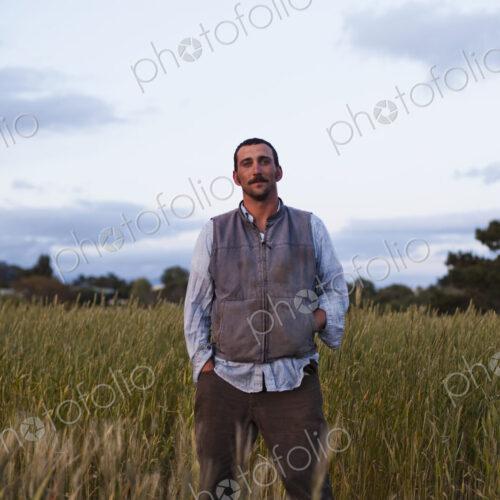 A man standing by a field of growing cereal crop, at the social care and work project,… A man standing by a field of growing cereal crop, at the social care and work project,…