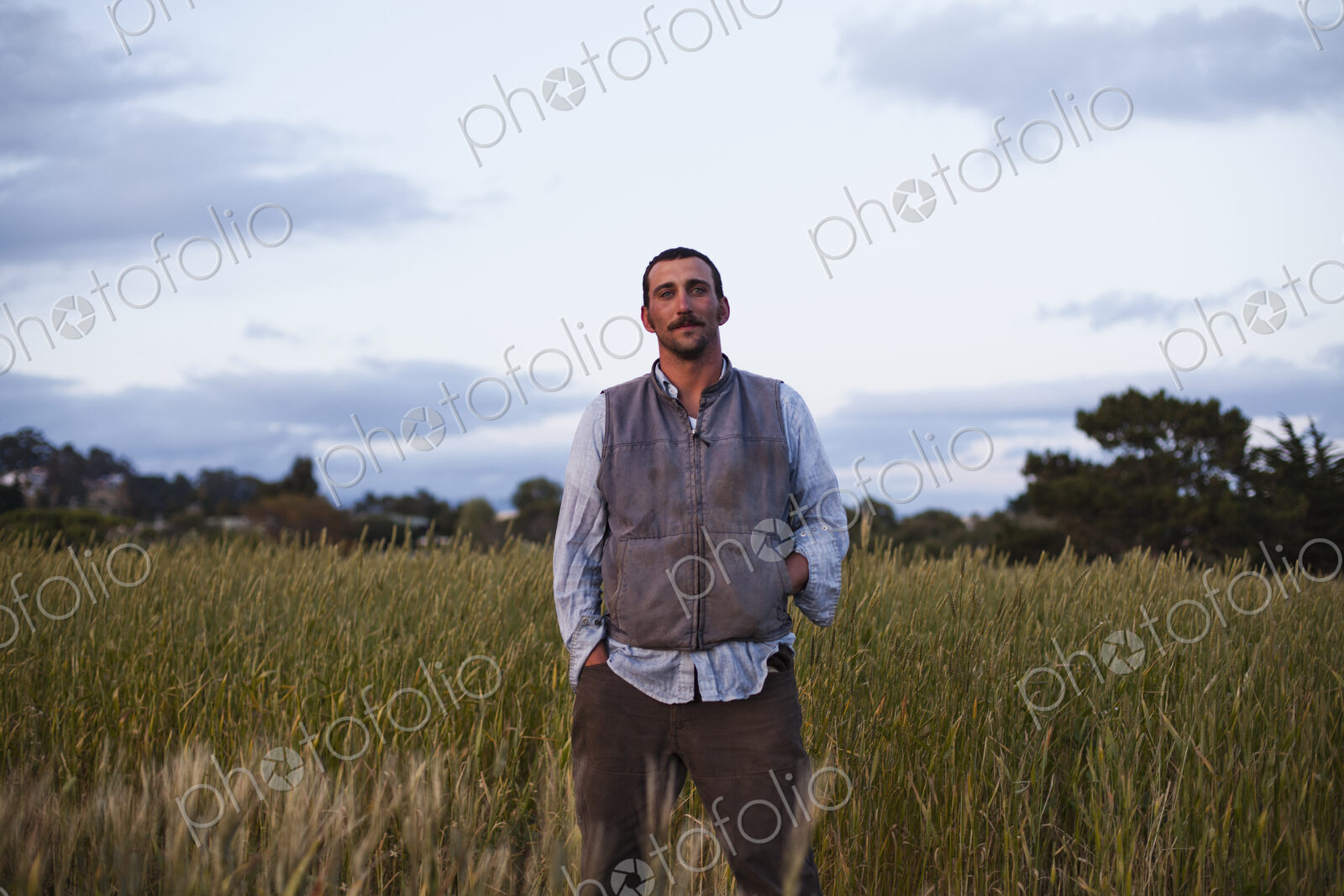 A man standing by a field of growing cereal crop, at the social care and work project,…