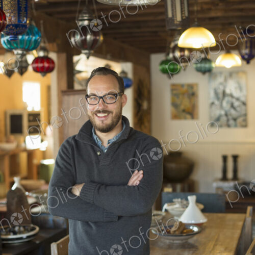 A man standing in a shop full of antique and decorative objects. Antique shop…