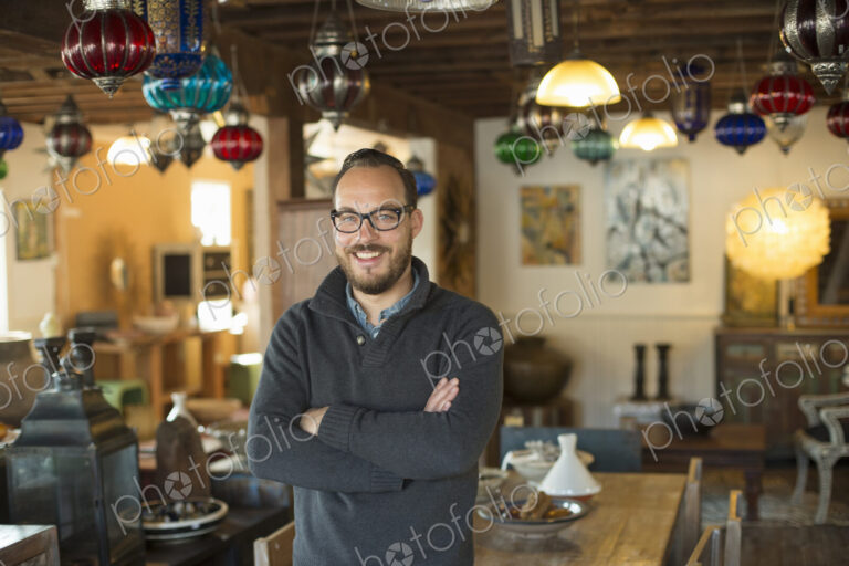 A man standing in a shop full of antique and decorative objects. Antique shop…