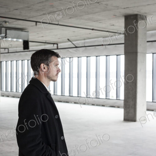 A man standing in an empty office space planning ahead, space to expand.