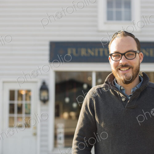 A man standing outside a store on street. Antique store. A man standing outside a store on street. Antique store.