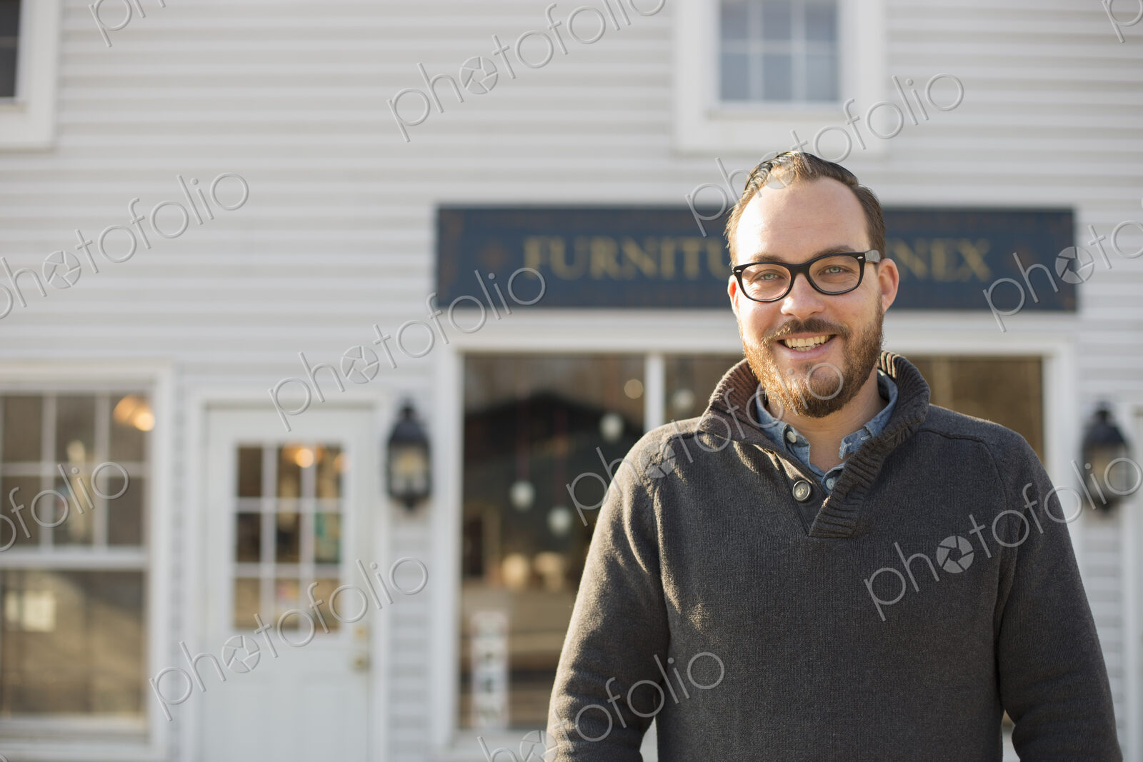 A man standing outside a store on street. Antique store.