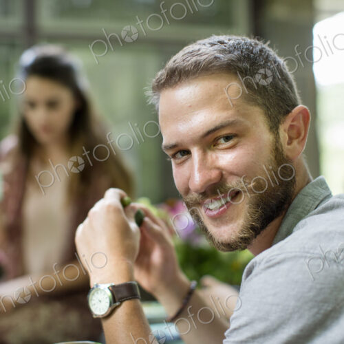 A man turning is head, seated at a table with a group of people. A man turning is head, seated at a table with a group of people.