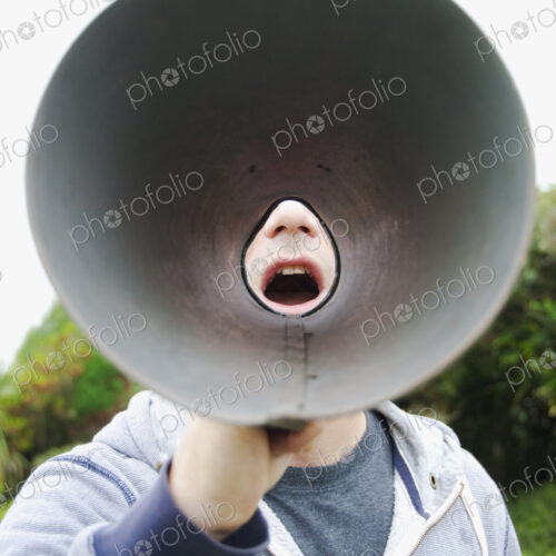 A man using a megaphone, view from the wide cone end. A man using a megaphone, view from the wide cone end.