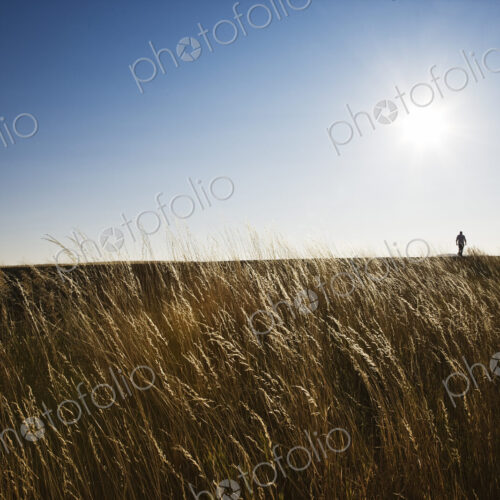 A man walking along the edge of a highway in eastern Washington State, USA.