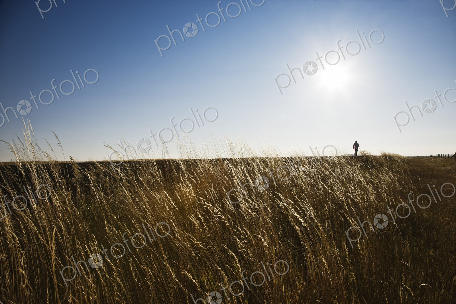 A man walking along the edge of a highway in eastern Washington State, USA.