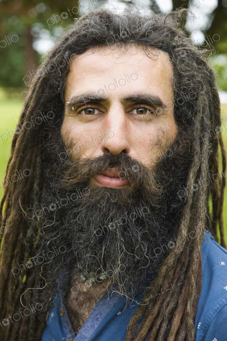 A man with long dreadlocks in a blue shirt.