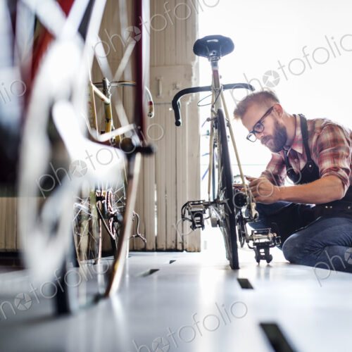 A man working in a bicycle repair shop. A man working in a bicycle repair shop.