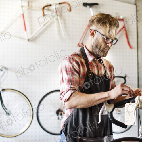 A man working in a bicycle repair shop. A man working in a bicycle repair shop.