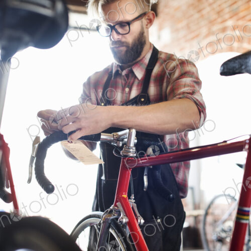 A man working in a bicycle repair shop. A man working in a bicycle repair shop.