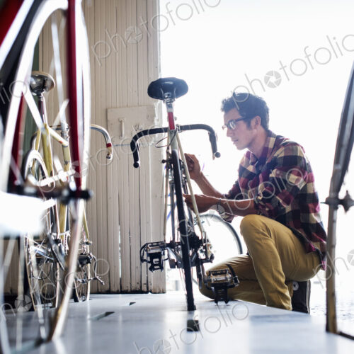 A man working in a bicycle repair shop. A man working in a bicycle repair shop.