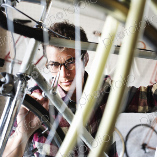 A man working in a bicycle repair shop. A man working in a bicycle repair shop.