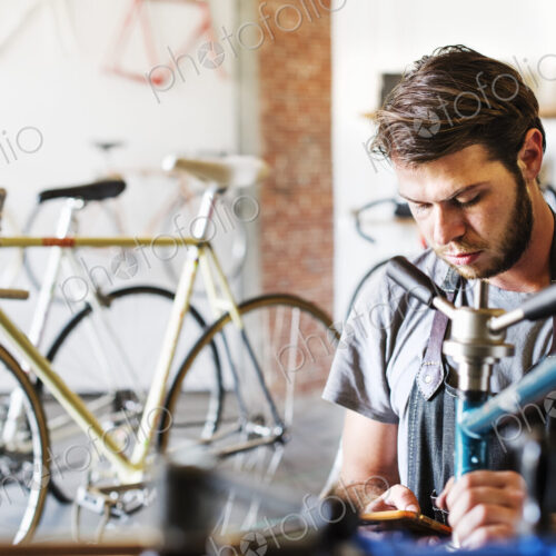 A man working in a bicycle repair shop. A man working in a bicycle repair shop.