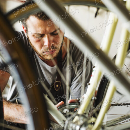 A man working in a bicycle repair shop. A man working in a bicycle repair shop.