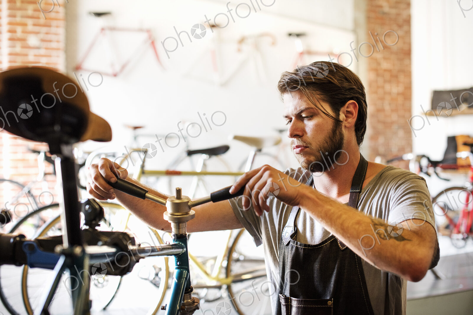 A man working in a bicycle repair shop, checking the frame of the bike.