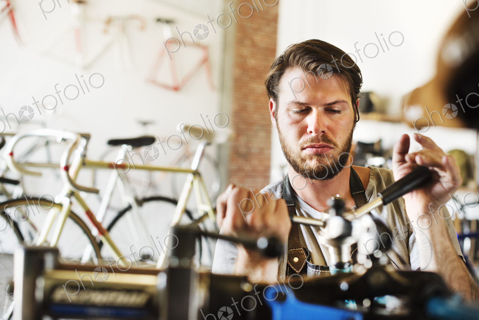 A man working in a bicycle repair shop, checking the frame of the bike.
