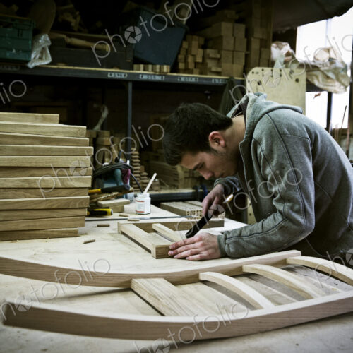 A man working in a furniture maker's workshop. A man working in a furniture maker's workshop.