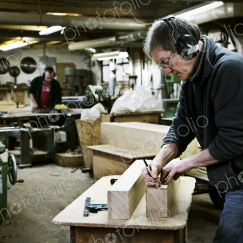 A man working in a furniture maker's workshop. A man working in a furniture maker's workshop.