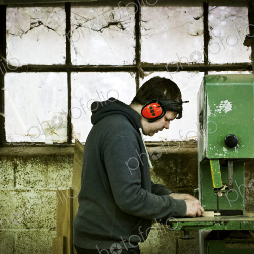 A man working in a furniture maker's workshop. A man working in a furniture maker's workshop.
