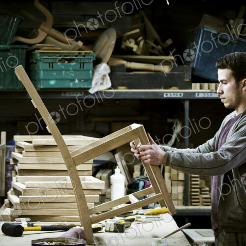 A man working in a furniture maker's workshop. A man working in a furniture maker's workshop.