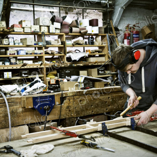 A man working in a furniture maker's workshop. A man working in a furniture maker's workshop.