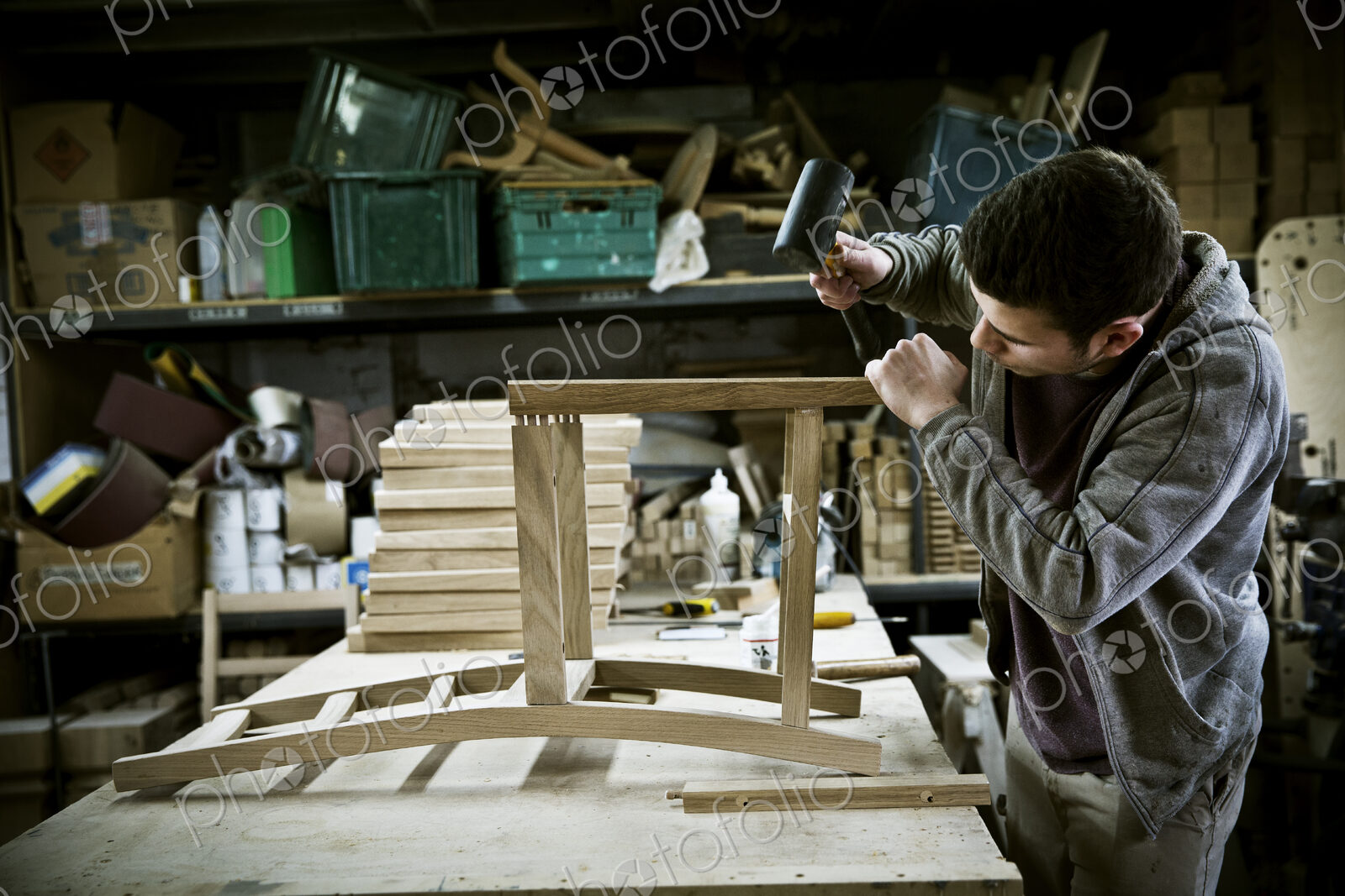 A man working in a furniture maker’s workshop assembling a chair.