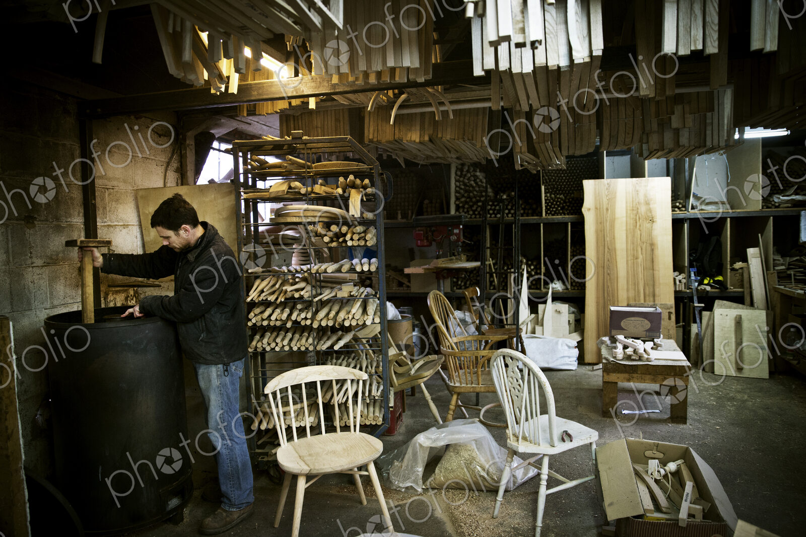 A man working in a furniture maker’s workshop. Windsor chairs.
