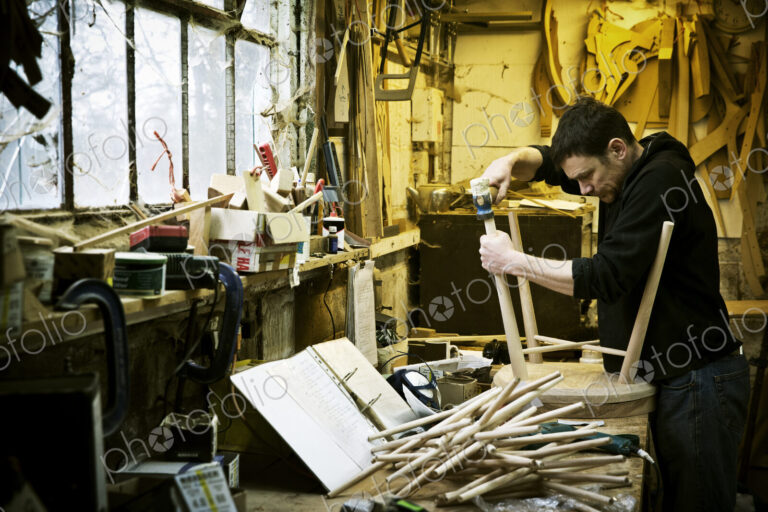 A man working in a furniture maker's workshop. Windsor chairs.