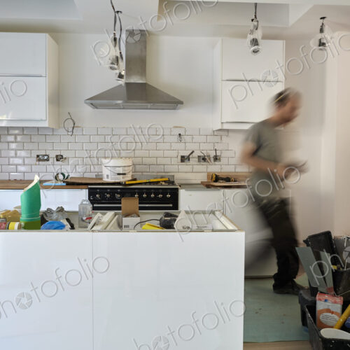 A man working in a kitchen, installing new units. Blurred motion. A man working in a kitchen, installing new units. Blurred motion.