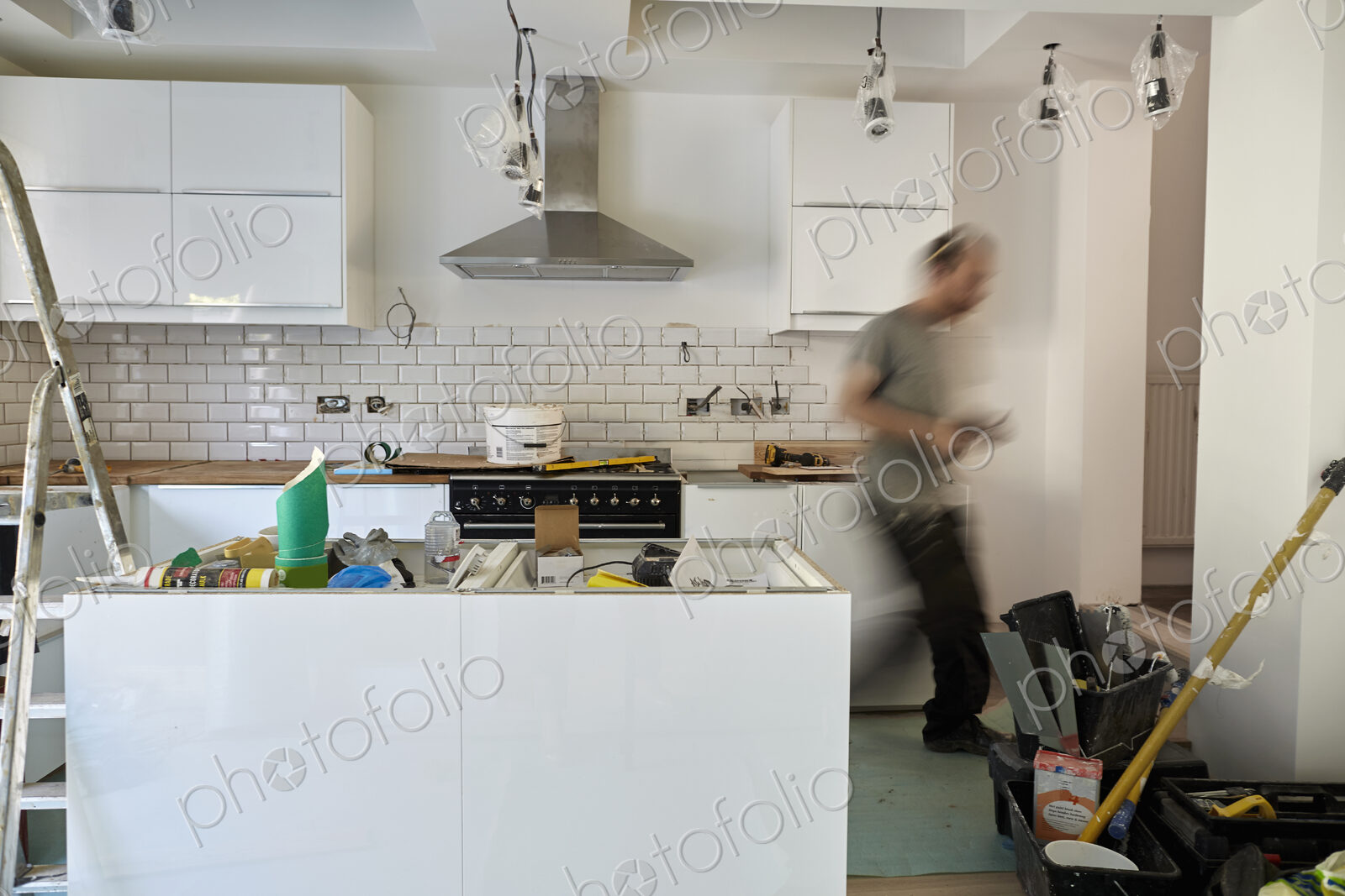 A man working in a kitchen, installing new units. Blurred motion.