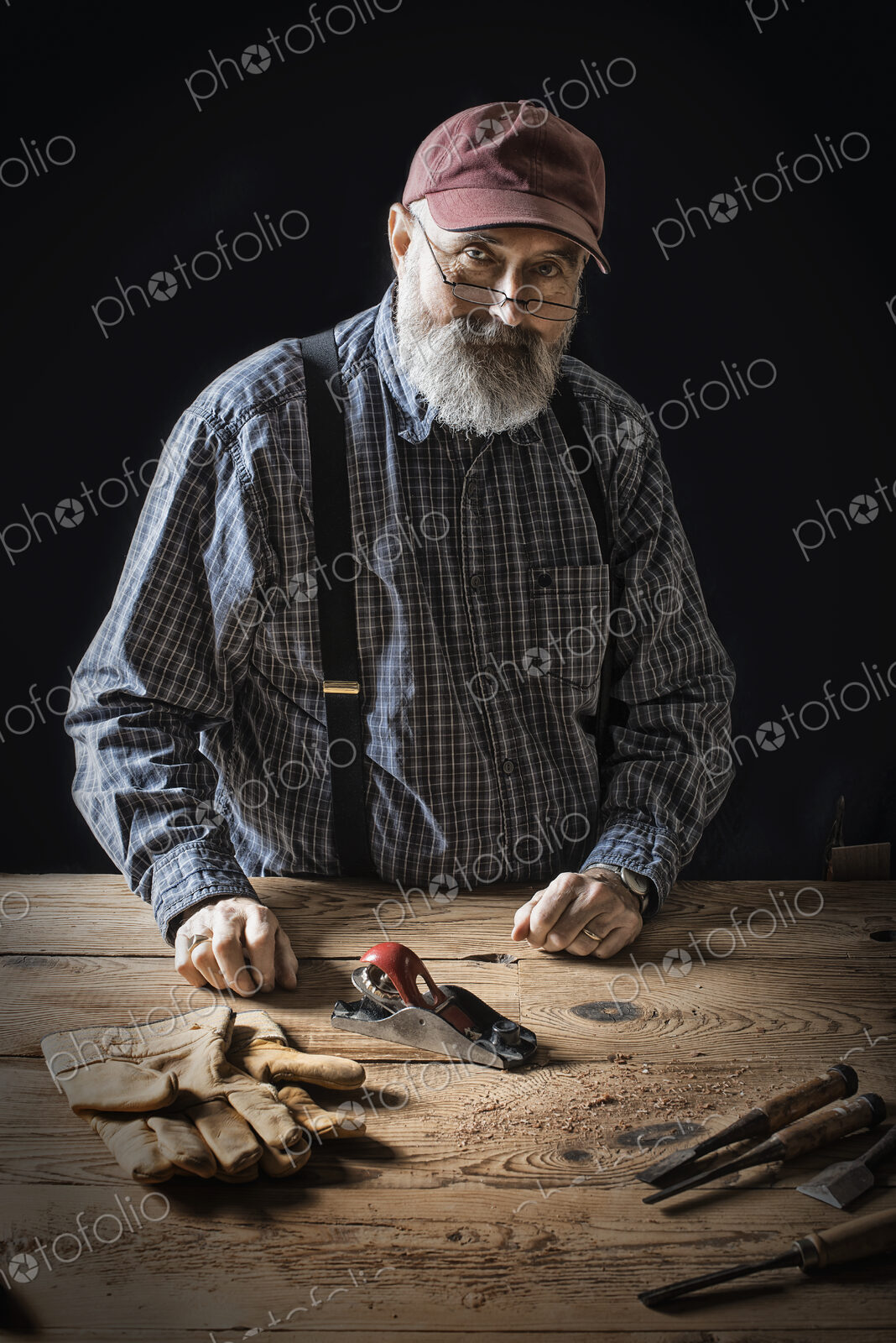 A man working in a reclaimed lumber yard workshop. Holding tools and working on a…