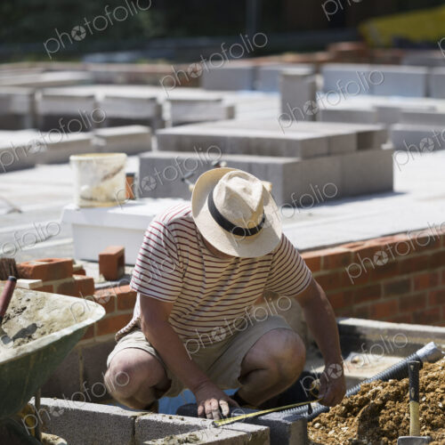 A man working on a construction site, laying foundations for a building.