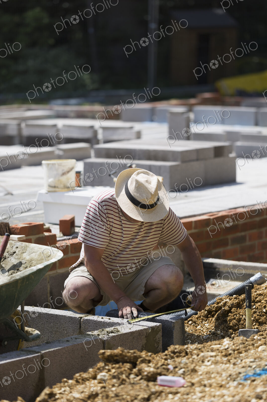 A man working on a construction site, laying foundations for a building.