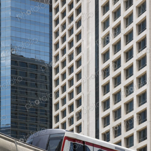 A mass transit train on an elevated track passing modern buildings in the central… A mass transit train on an elevated track passing modern buildings in the central…