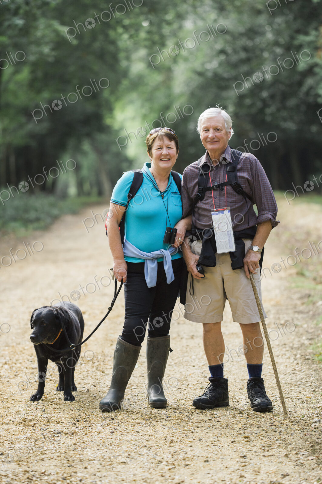 A mature couple hiking with their dog.