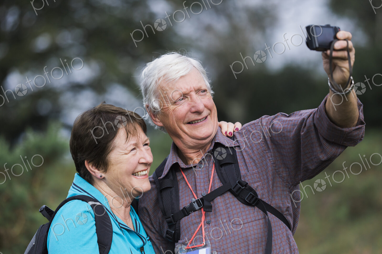 A mature couple taking a selfy photograph while out walking.