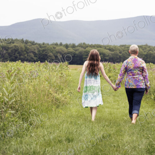 A mature woman and a young girl in a wildflower meadow. A mature woman and a young girl in a wildflower meadow.