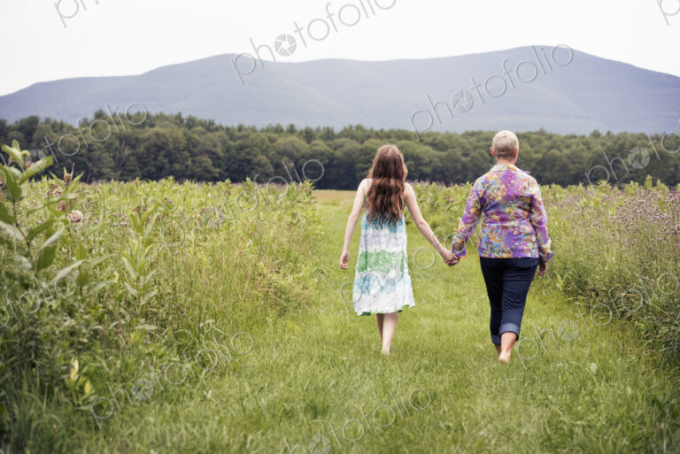 A mature woman and a young girl in a wildflower meadow.