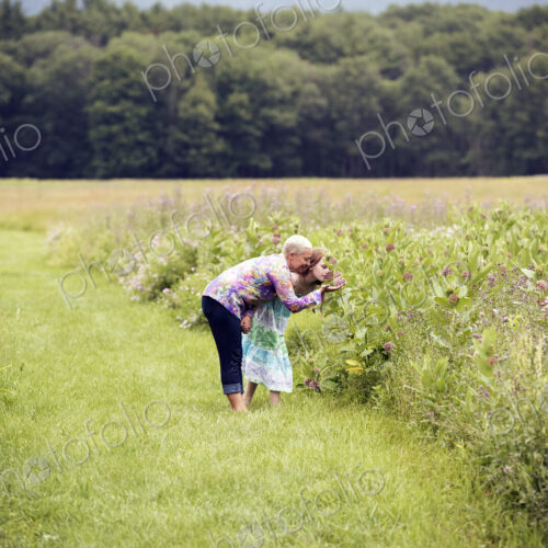 A mature woman and a young girl in a wildflower meadow. A mature woman and a young girl in a wildflower meadow.