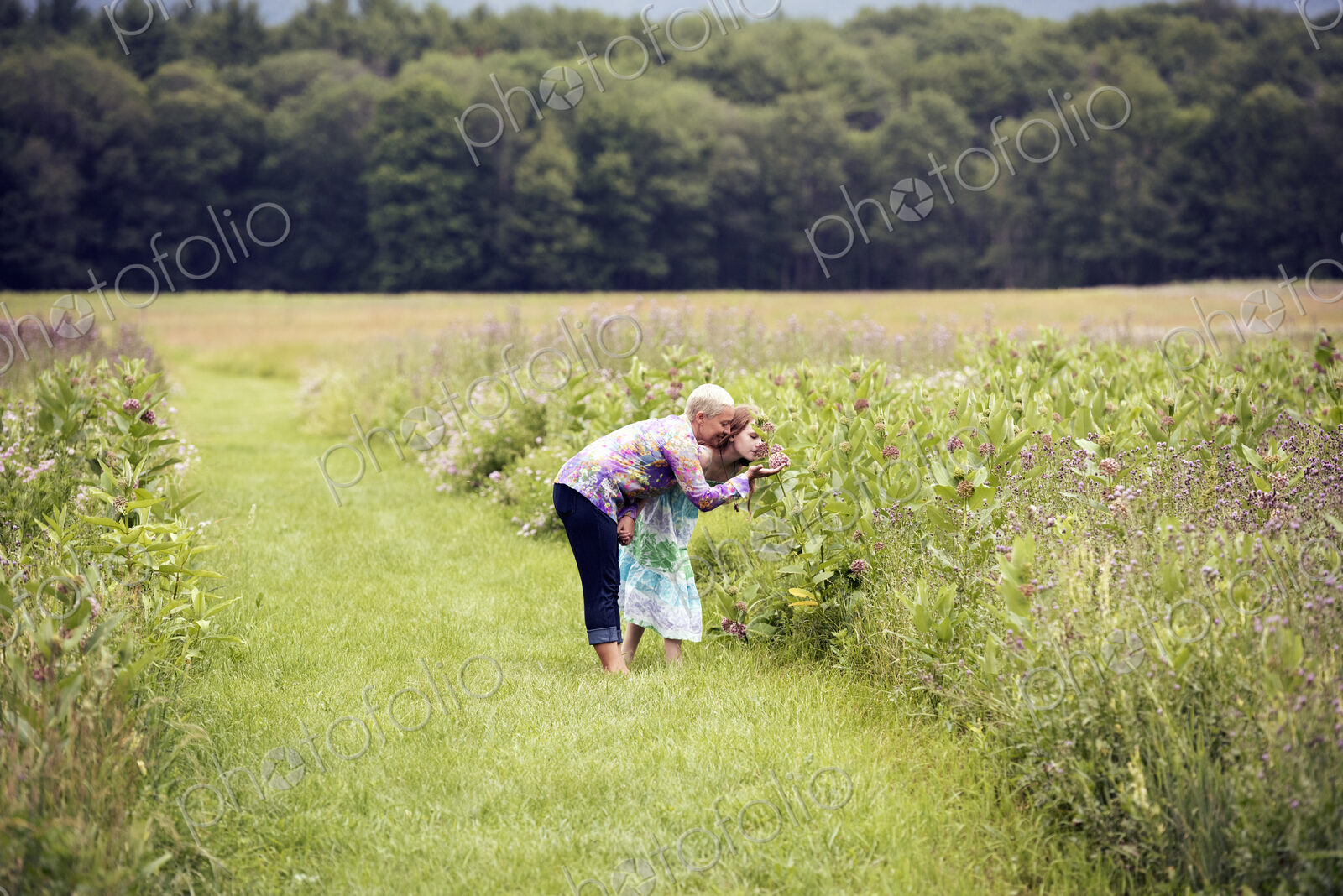 A mature woman and a young girl in a wildflower meadow.