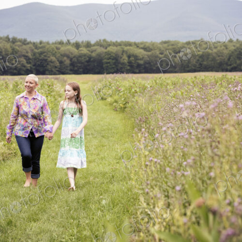 A mature woman and a young girl in a wildflower meadow. A mature woman and a young girl in a wildflower meadow.