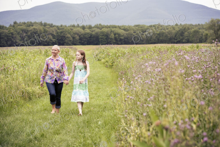A mature woman and a young girl in a wildflower meadow.
