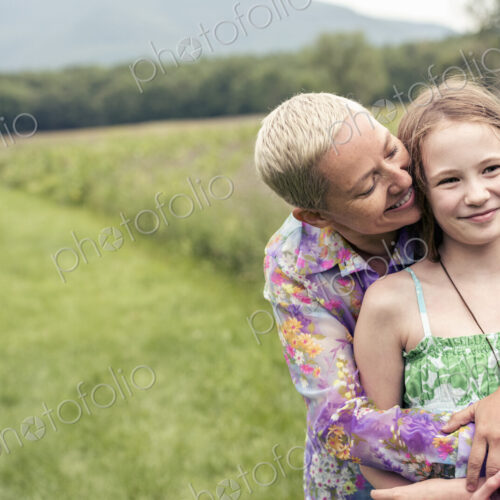 A mature woman and a young girl in a wildflower meadow. A mature woman and a young girl in a wildflower meadow.