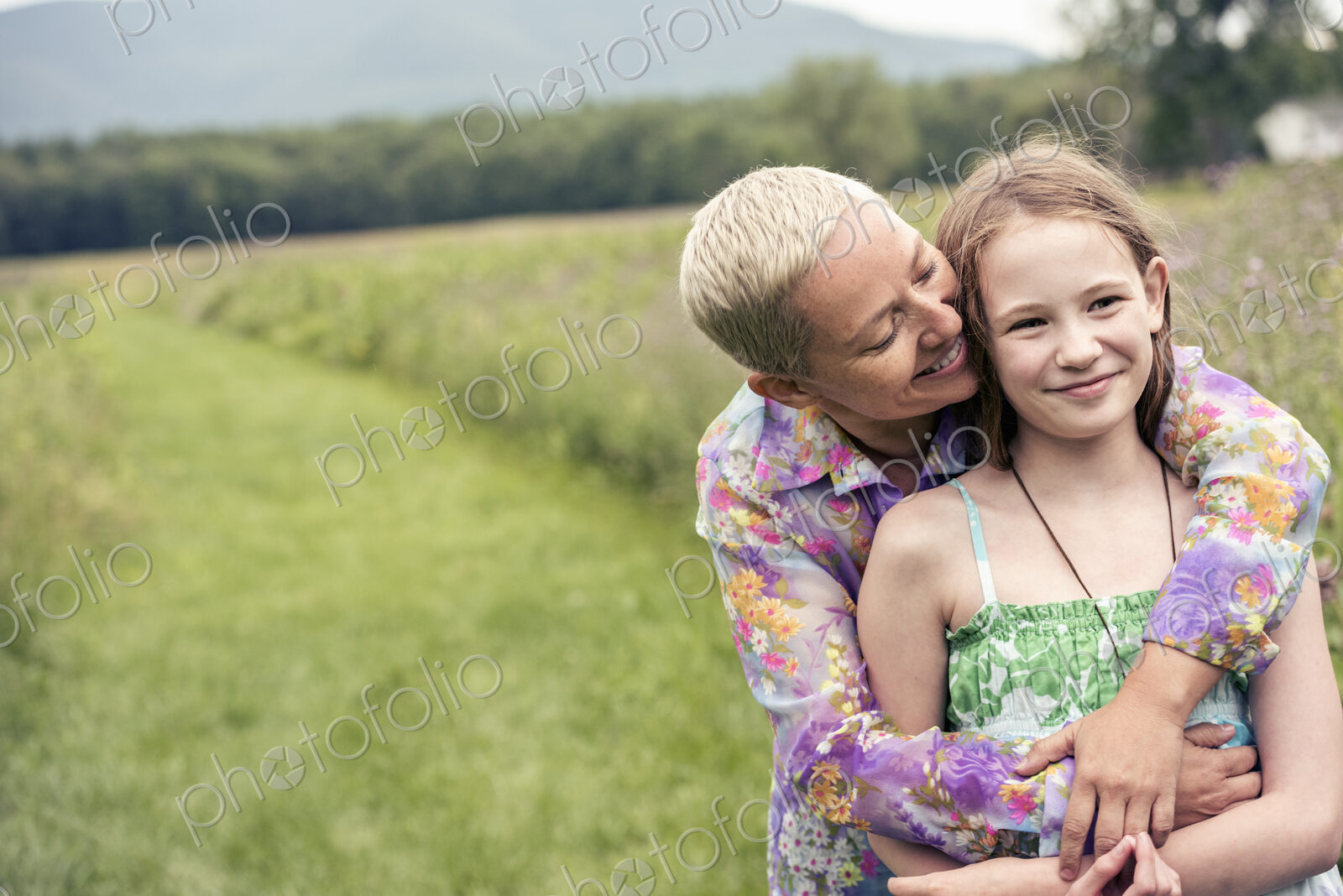 A mature woman and a young girl in a wildflower meadow.