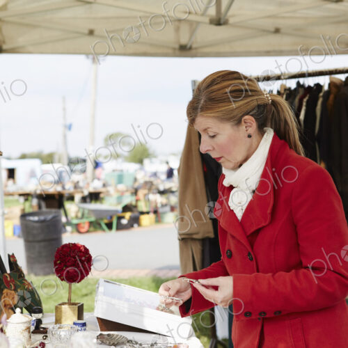 A mature woman bargain hunter browsing through vintage jewellery items